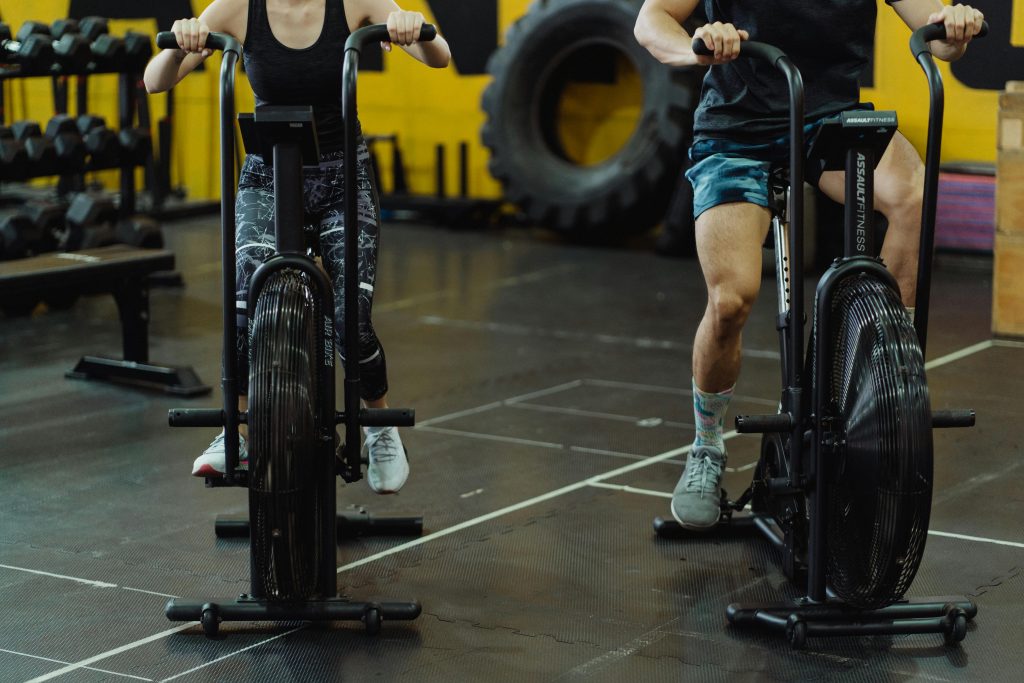 Two people exercising on stationary bikes at a modern gym.